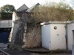 Photographie en couleurs d'un massif de maçonnerie à l'angle de deux rues.