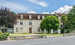 Photo de la mairie, un bâtiment avec un mur à la chaux avec pierres apparentes et un toit en tuile.