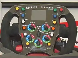 Bouton jaune marqué « over » en haut à gauche du volant d'une Toyota F1 de 2008.