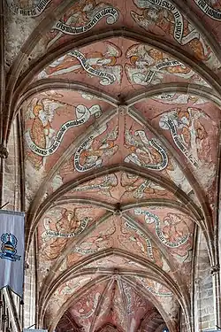 Photo montrant un chœur d'église gothique, avec des voûtes d'ogives peintes.