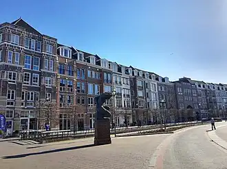 Photographie de façades d'immeubles en briques présentant une continuité urbaine.