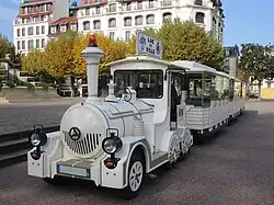 Vue sur un petit train stationné sur une place.