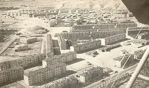 Photographie aérienne en noir et blanc d'un quartier en construction.