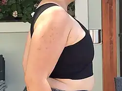 Photographie de profil du torse d'une personne portant un binder.