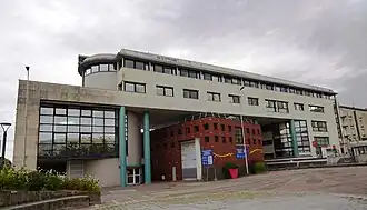 Le bâtiment de couleur bordeaux est l'agence commerciale des TUL et l'ancienne station.