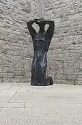 sculpture en bronze nommée Trauernde (deuil) et située dans l'ossuaire du cimetière militaire allemand de Dagneux en France.