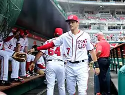 Un joueur de baseball jette son gant sur le banc de touche d'un stade de ligue majeur américain.