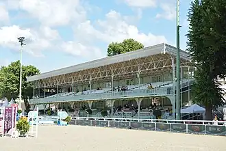 Tribune à deux niveaux où sont assis les spectateurs