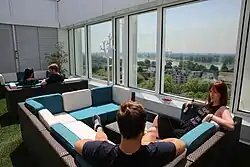 Des personnnes se reposant dans un lieu de convivialité avec vue sur une vallée.