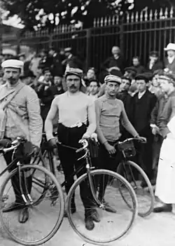 Photographie de coureurs se tenant debout à côté de leur vélo.