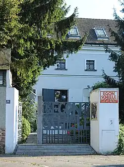 Photo couleur d'une entrée de jardin avec une façade claire derrière