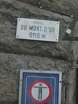 Plaque posée à l'entrée du tunnel avec l'indication «&nbsp;Tunnel du mont-d'Or 6115 m&nbsp;».