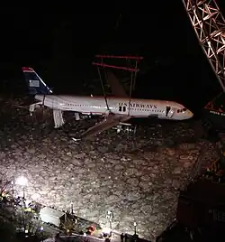 Photo de nuit montrant l'avion en train d'être tiré de la rivière gelée par une grue.