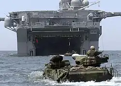 Un véhicule amphibie AAV-7 devant le radier inondable de poupe de l'USS&nbsp;Bonhomme Richard, s'apprêtant à enradier.