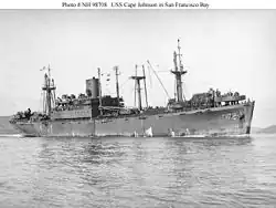 Photo de profil en noir et blanc du navire USS Cape Johnson naviguant dans la baie de San Francisco.