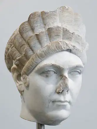 tête de femme au nez cassé, avec une coiffure élaborée sur trois niveaux.