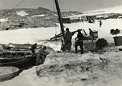 Des hommes déchargeant du matériel d'un navire.