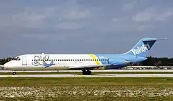 Photo du côté gauche d'un avion de ligne aux couleurs blanches à l'avant et bleues à l'arrière, roulant sur un aéroport.