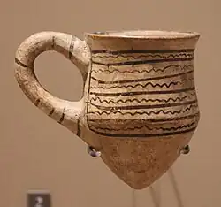 Chope miniature à fond pointu munie d'une anse, peinte de lignes ondulées. Kültepe, Musée du Louvre.