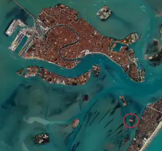 Photographie couleur vue du ciel montrant l'emplacement de San Lazzaro. Les nuances de bleu dans l'eau indiquent clairement le chenal permettant d'accéder à l'île.