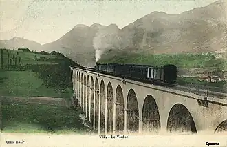 Carte postale en couleur du représentant le viaduc ferroviaire dans une vue à niveau, avec un train à vapeur le traversant, vers le tournant du XXe&nbsp;siècle..