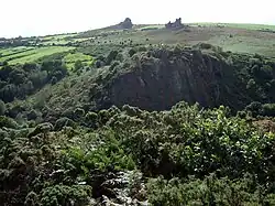 Une vallée boisée et encaissée, avec des formations rocheuses sur la crête.