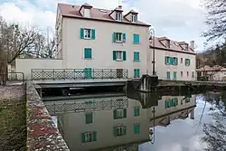 Vue d'une maison construite à cheval sur une rivière.