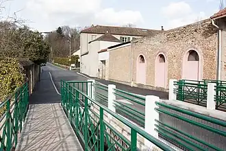 Vue d'une route à la sortie d'un pont ; bâtiments sur la droite.