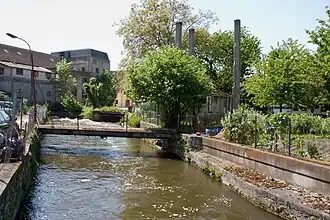 Vue d'un bâtiment d'une ancienne usine sur les bords d'une rivière.