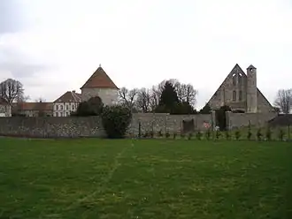 Pignon d'une grange, pigeonnier et corps de logis derrière un haut mur