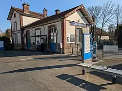 L'entrée de la halte avec le mobilier Transilien devant l'ancien bâtiment voyageurs.