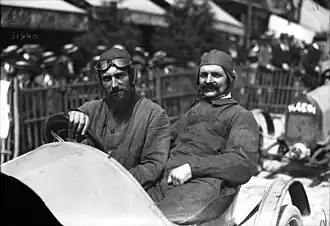 Photo de deux hommes assis dans une BNC et prenant la pose.