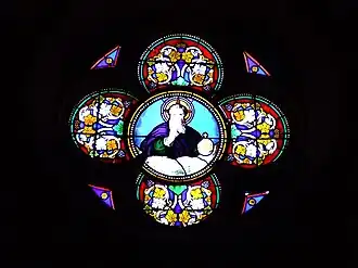 Vitrail en médaillon au-dessus du portail occidental représentant Dieu le Père éternel qui manifeste sa toute-puissance en tenant à sa gauche la Terre.