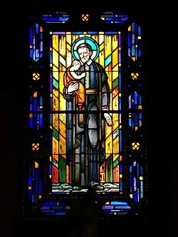 Vitrail entouré de claustras en béton représentant Saint Vincent de Paul