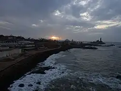 Vue du cap Comorin au lever du soleil avec une partie de la ville de Kânyâkumârî sur la gauche et le mémorial du rocher de Vivekananda et la statue de Thiruvalluvar sur la droite.