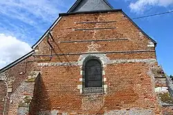 Le mur de la nef porte de nombreuses marques de consolidation.