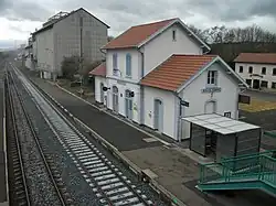 Les deux voies de la gare à gauche, en direction de Clermont-Ferrand, et le bâtiment voyageurs à droite