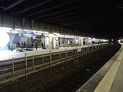 Au fond, les quais du tramway, après rénovation. Au premier plan, une voie et un quai de la gare SNCF.