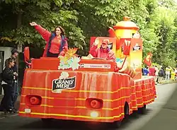 Des chars aux couleurs des marques défilent.