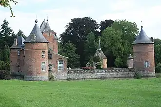 Le château de Rametz est construit en briques avec des moellons en pierre bleue, sur un soubassement en grès ; la photo montre le plan rectangulaire de la forteresse cantonnée de tours cylindriques et entourée de douves.