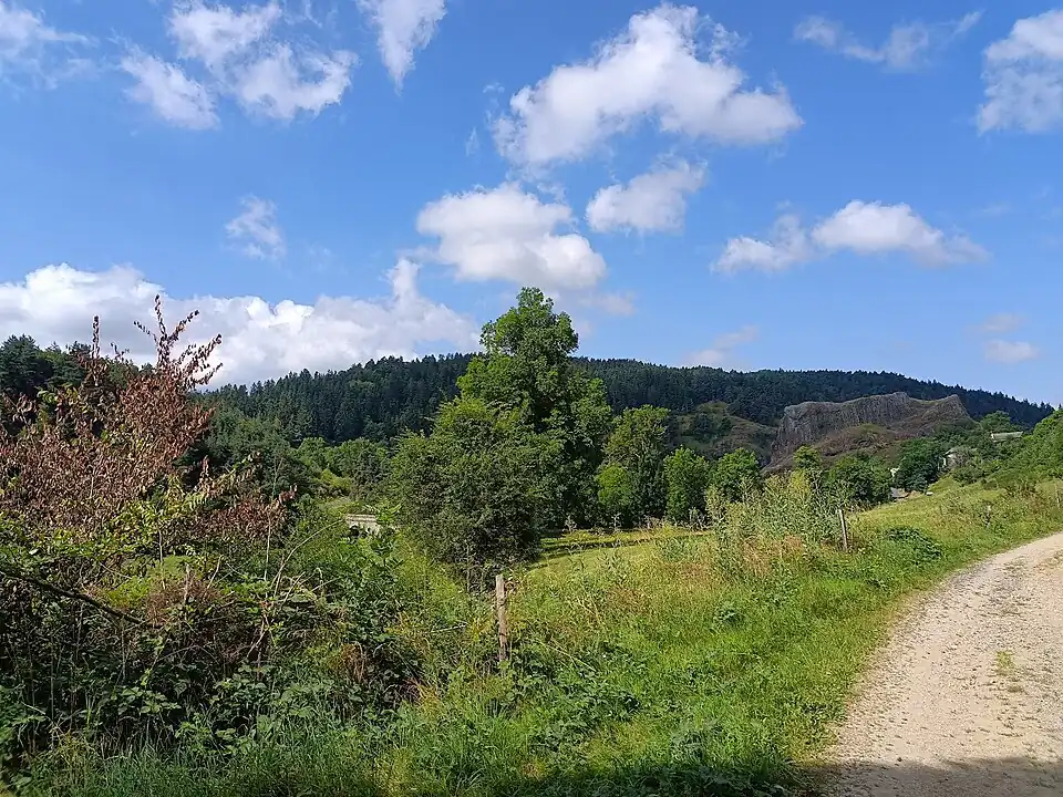 Vue du Rocher d'Eynac et du pont sur la Sumène en août 2024, depuis le chemin de Saint-Jacques-de-Compostelle.