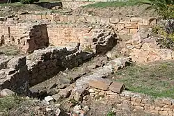 Photographie couleur de murs ruinés dépassant à peine du sol