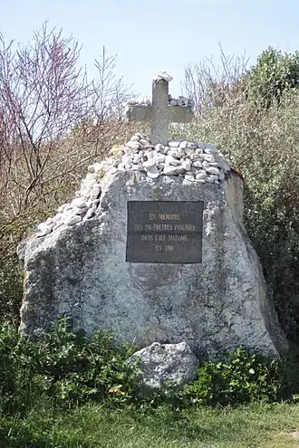 Stèle avec plaque gravée rappelant les prêtres réfractaires enterrés.
