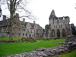 On voit une photo de l'abbaye de Wenlock. À droite le monastère qui est toujours debout. À gauche les ruines de l'ancien abbaye
