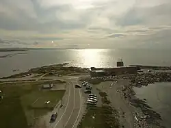 L’Onondaga en 2012 et la crête rocheuse initialement retenue pour son installation situé à l'ouest du quai