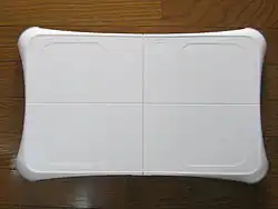 Photographie de la Wii Balance Board, une balance blanche en plastique.
