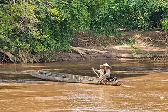 Femme dans sa barque au Laos lors d'une pêche dans le Mékong.