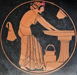 Femme à la toilette. Peintre : Douris, potier : Euphronios, v. 500. Médaillon d'un kylix attique à figures rouges, D. 26,9&nbsp;cm. Met.