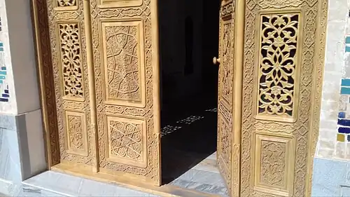 Porte en bois ornée de la médersa Dusmatbay à Samarcande.