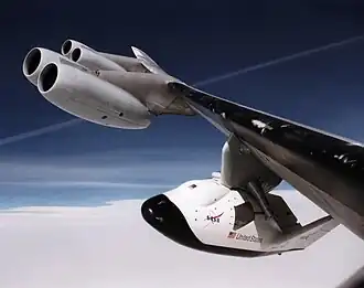 Le X-38, accroché au pylône d'emport, est visible grâce au hublot percé dans le fuselage.